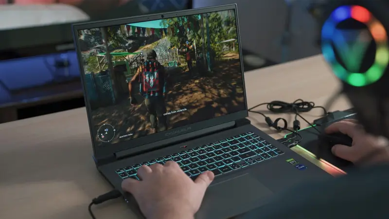 Mani su un portatile da gioco con un gioco in terza persona sullo schermo