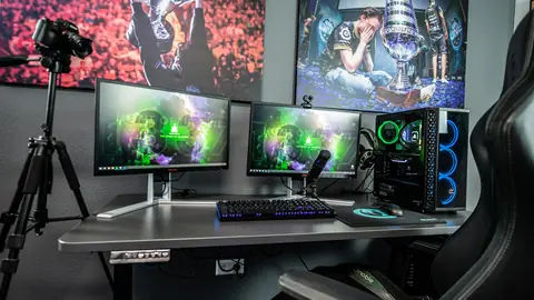 Postazione con due monitor, PC con ventole illuminate e sedia da gioco