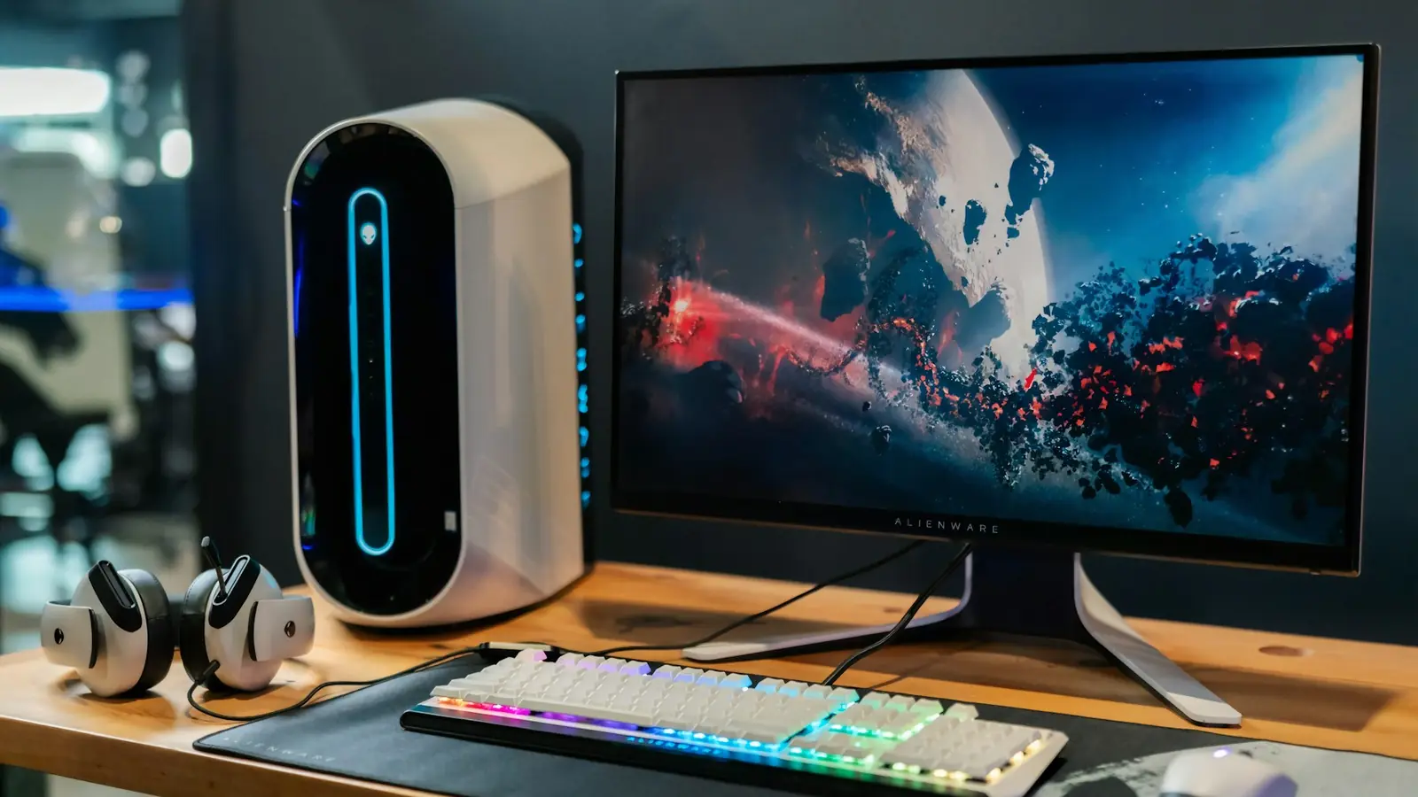 Scrivania con PC bianco, monitor, tastiera illuminata e cuffie