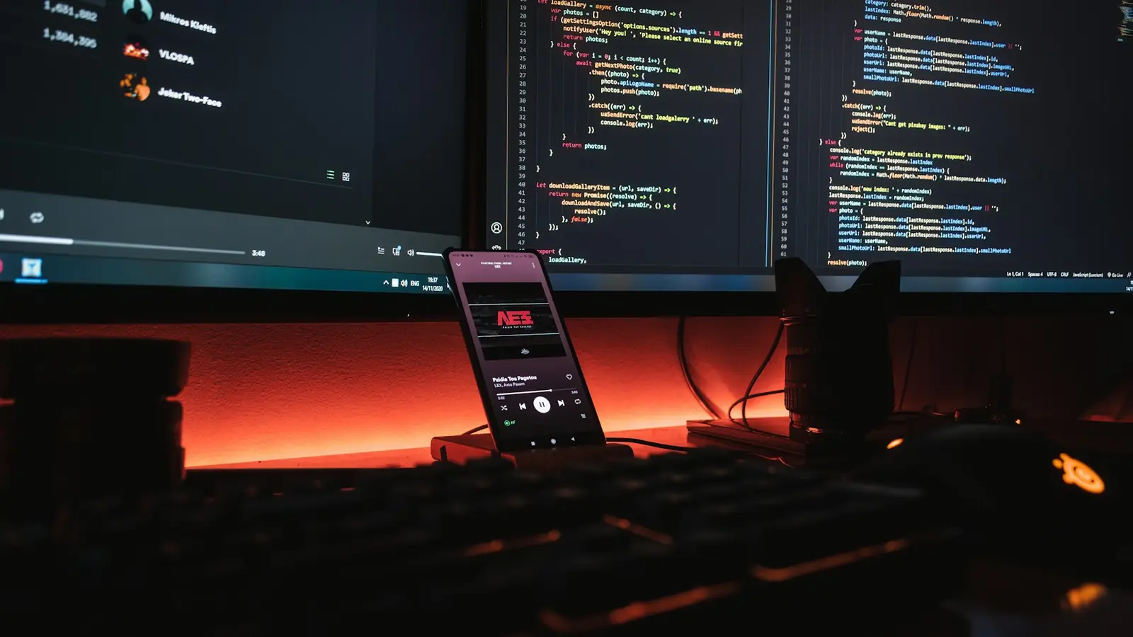 Monitor con codice e luce d'ambiente arancione su una scrivania