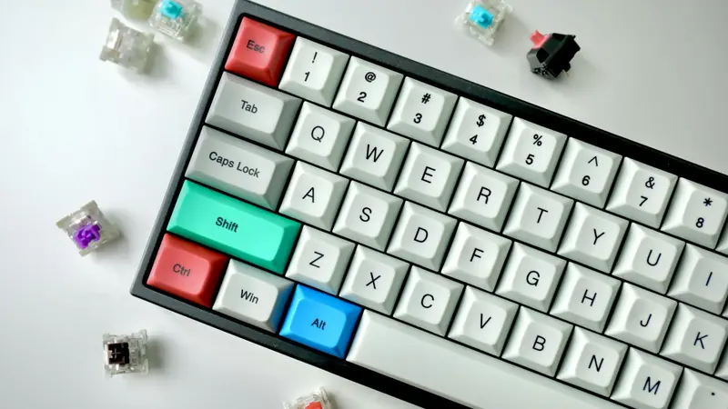 Tastiera meccanica compatta con alcuni switch sparsi sul tavolo